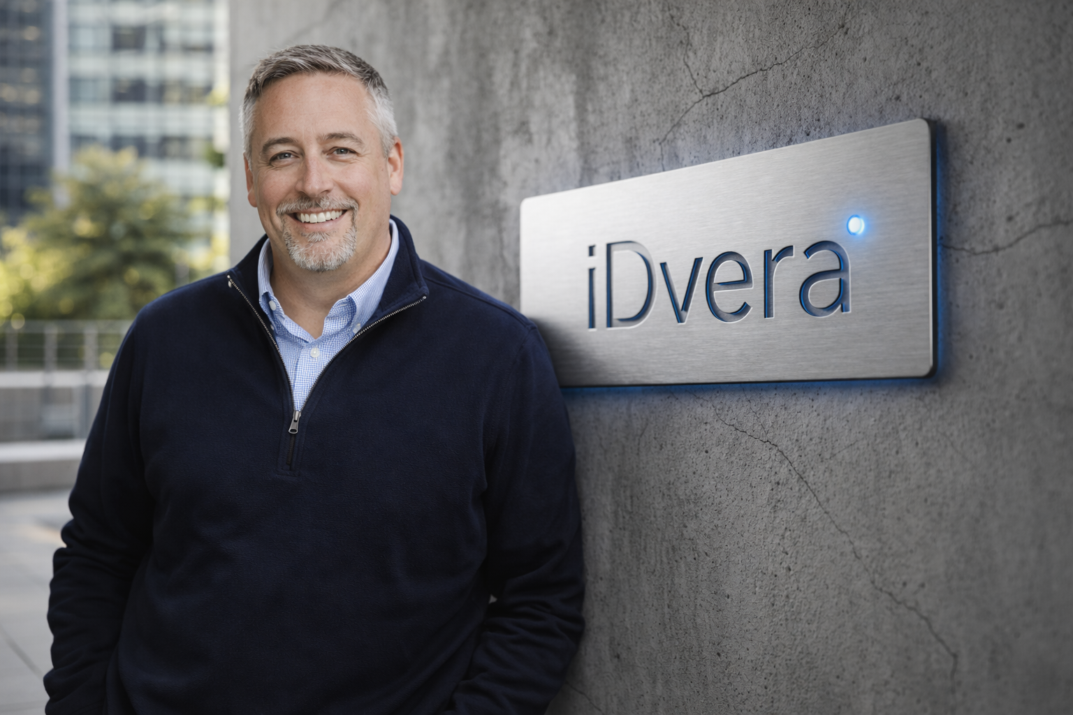 Stephen Kaniewski, Co-Founder & COO of iDvera, standing next to the iDvera sign